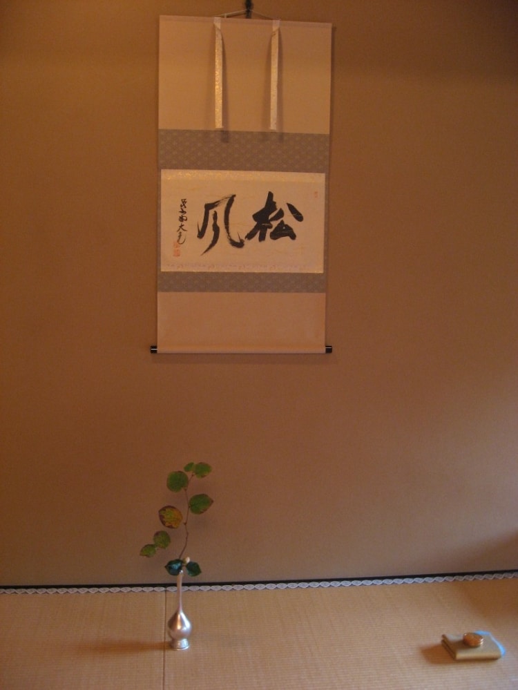 Avec le vent qui souffle dans les pins c’est presque la fin de l’automne qui s’annonce…. La fragilité et la simplicité de cet Ikebana disposé lors de la cérémonie de thé de novembre s’accordent avec le message du kakejiku.